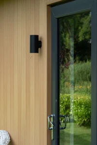 Black frame sliding door on light brown wooden panelled modular home in Connacht